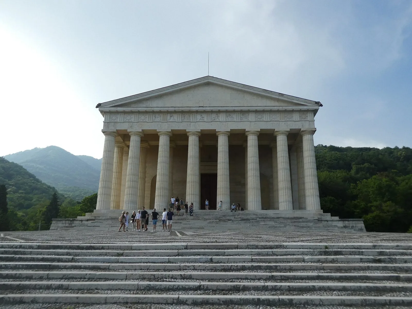La facciata del Tempio canoviano di Possagno con il colonnato dorico e la scalinata, circondato dalle colline boscose ai piedi del Monte Grappa